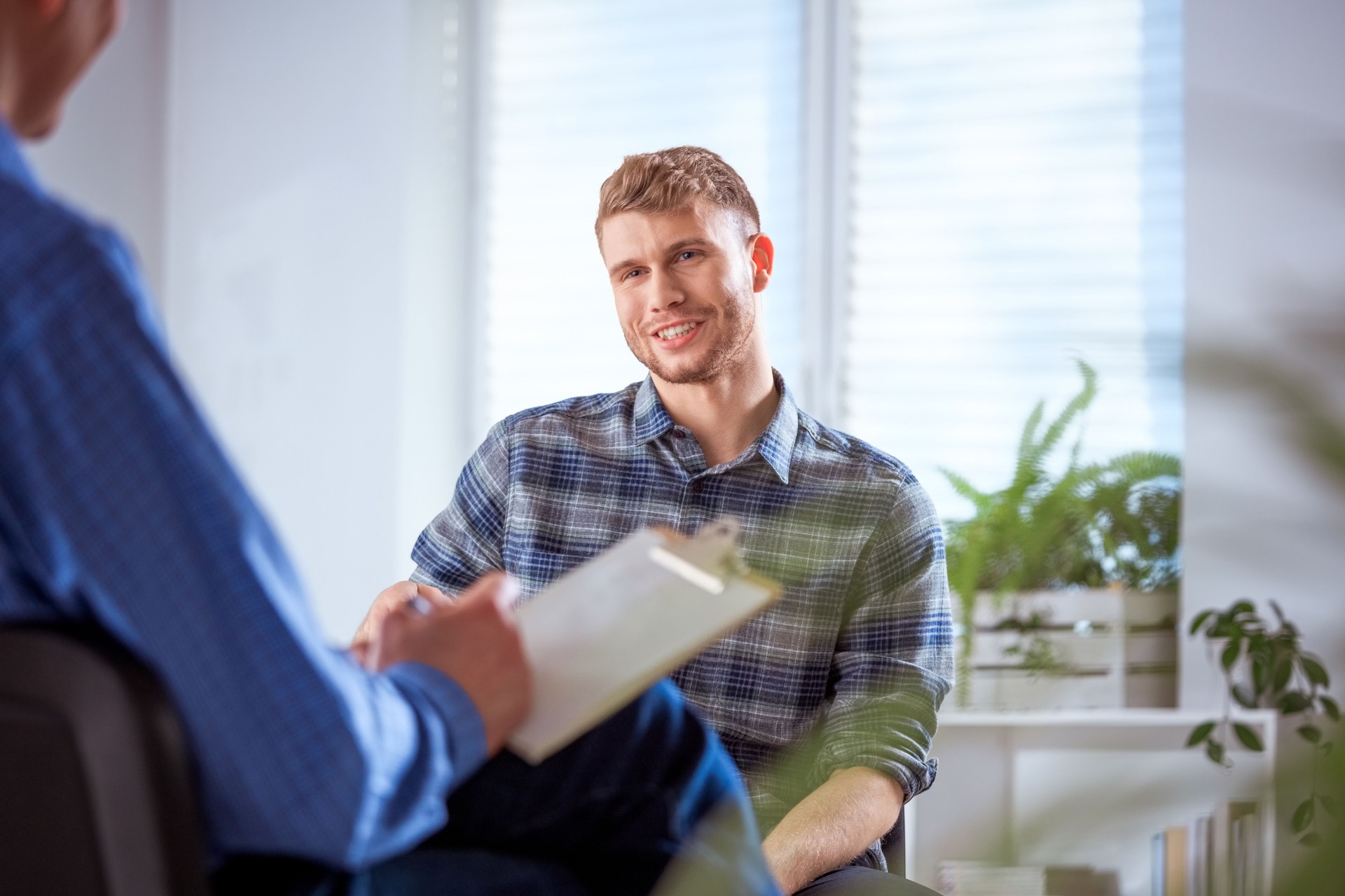 Smiling student discussing with male therapist