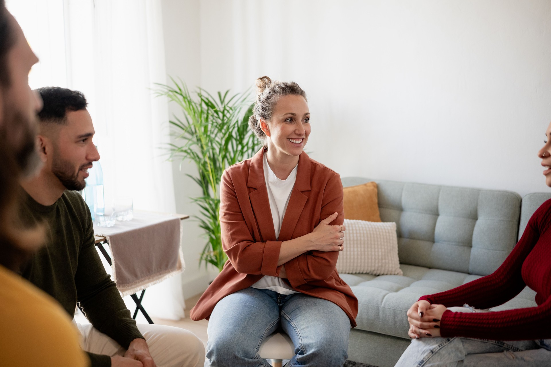 Group therapy session: patients discussing with therapist in cozy room